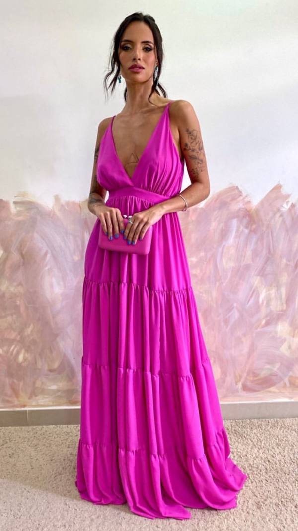 Vestido longo fúcsia com decote V, alças finas e saia fluida em camadas.