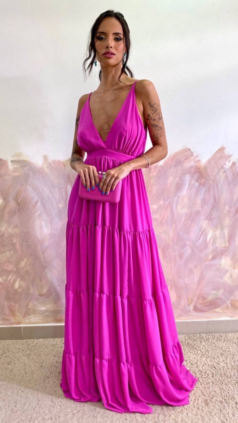 Vestido longo fúcsia com decote V, alças finas e saia fluida em camadas.