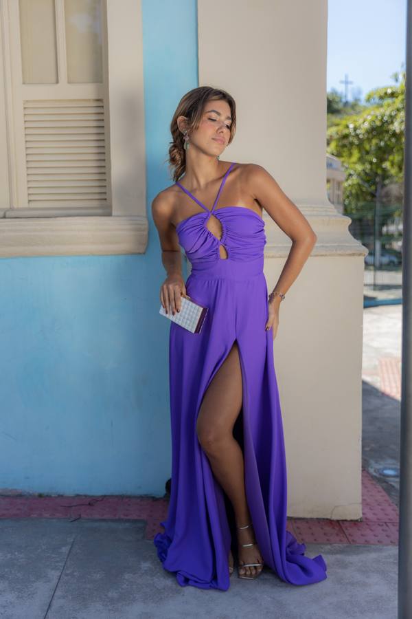 Vestido longo roxo em tecido fluido, com decote frente única, recortes no busto e fenda frontal destacada na saia.