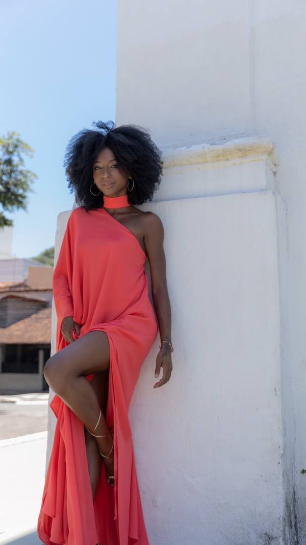 Vestido longo coral fluido de um ombro só, com detalhe no pescoço e fenda profunda na saia.