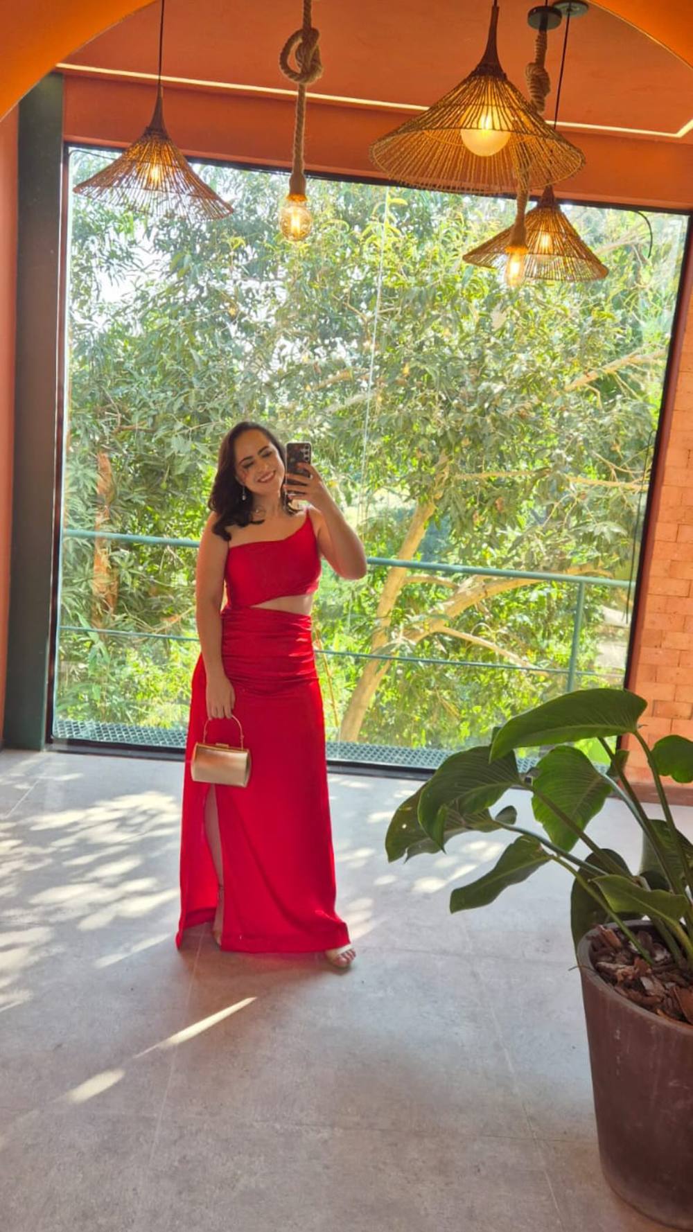 Vestido longo vermelho de um ombro só, com recorte na cintura e fenda lateral na saia.