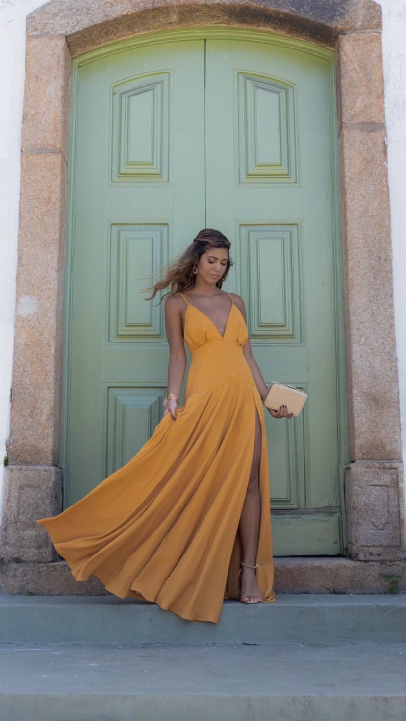 Vestido longo mostarda em tecido fluido, com alças finas, decote V e fenda na saia.