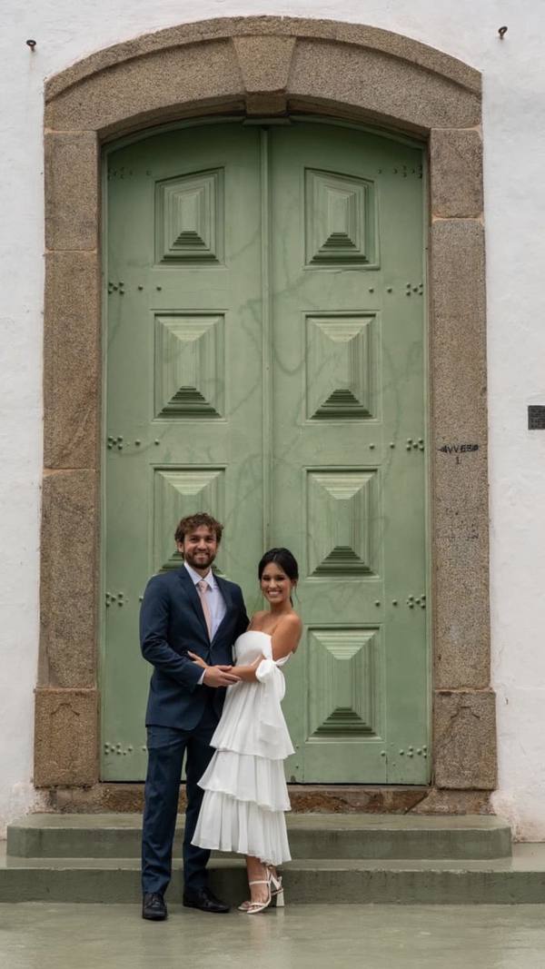 Vestido midi branco tomara que caia, com caimento fluido e saia em camadas de babados.