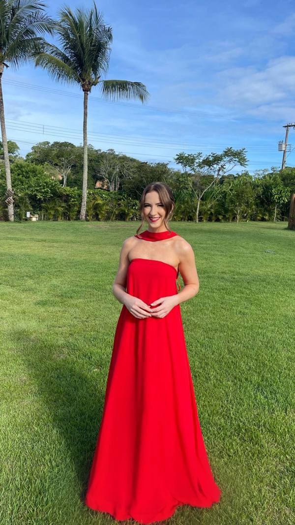 Vestido longo vermelho de caimento fluido, decote tomara que caia com detalhe de faixa no pescoço.