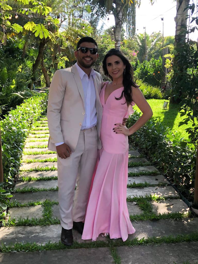 Vestido longo rosa com decote V, alças com babados e saia ajustada de caimento fluido.