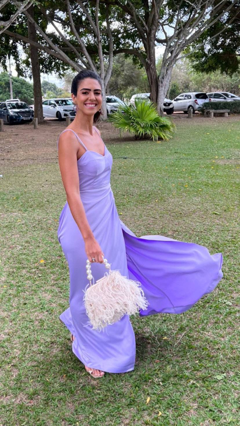 Vestido longo lilás de alça fina, decote levemente coração, saia fluida com fenda lateral e caimento leve.