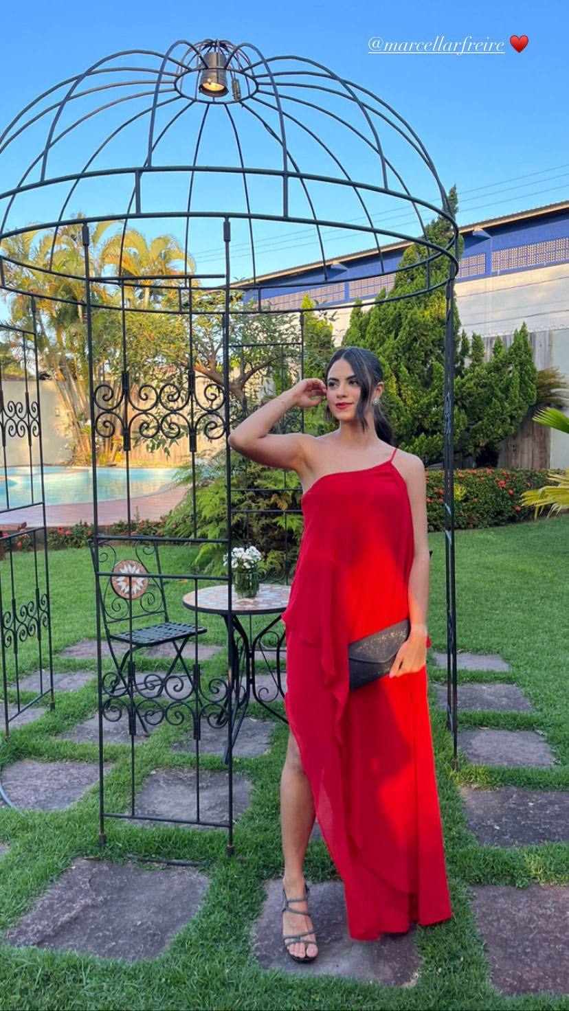 Vestido longo vermelho de um ombro só, em tecido fluido com caimento leve e fenda lateral.