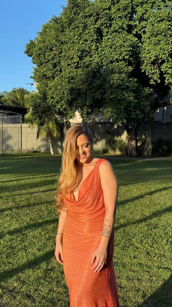 Vestido longo terracota com brilho, decote V drapeado e caimento reto.