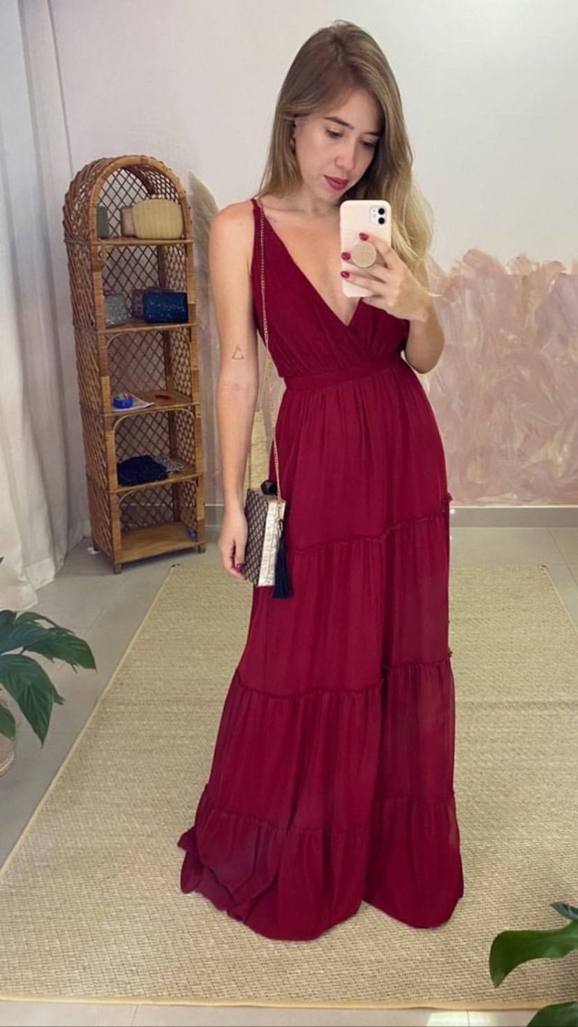 Vestido longo marsala de caimento fluido, com decote V, alças finas e saia em camadas.