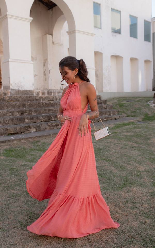 Vestido longo coral em tecido leve, decote frente única, saia fluida com fenda e babado na barra.