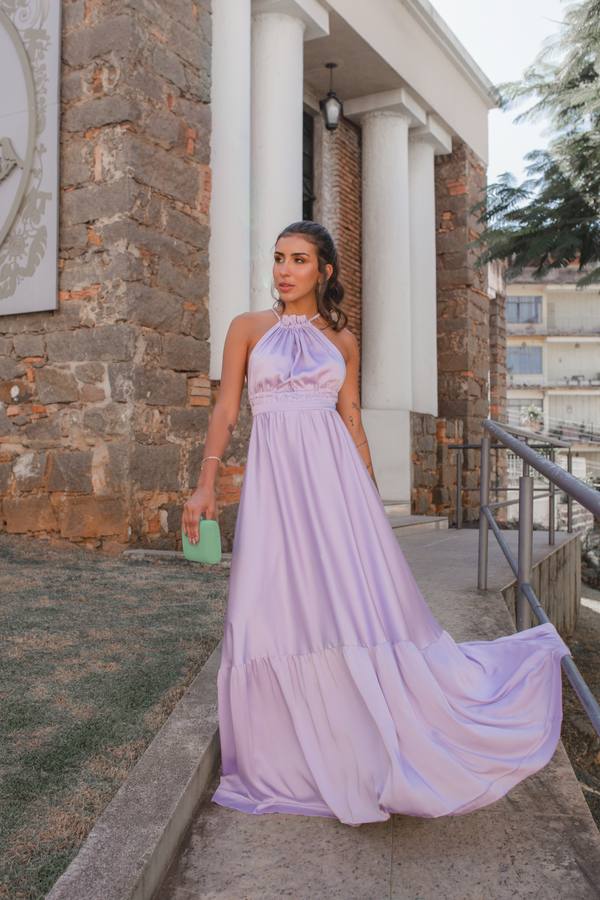 Vestido longo lilás em tecido acetinado, com decote frente única, cintura marcada e saia fluida.