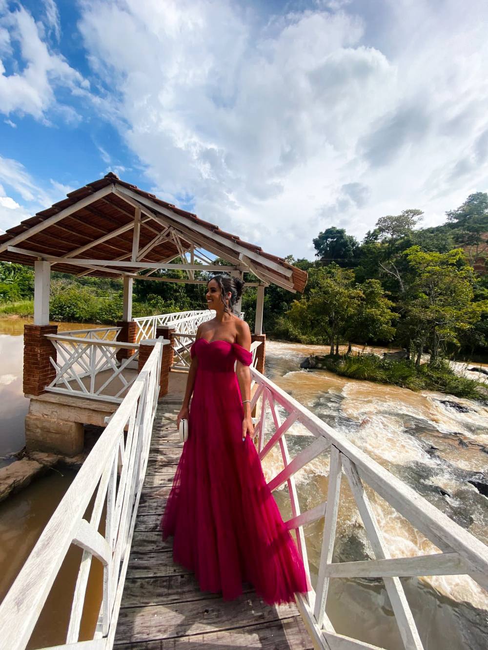 Vestido longo fúcsia em tule com decote tomara que caia, mangas caídas e saia fluida.