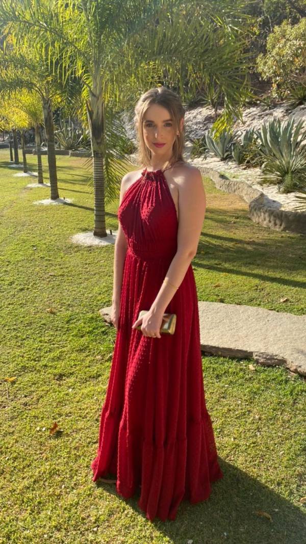Vestido longo vermelho de saia fluida, decote frente única e tecido leve com textura de poá.