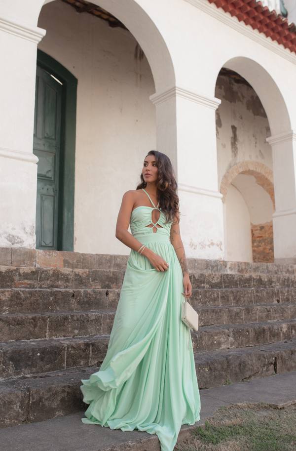 Vestido longo verde claro em tecido fluido, decote frente única com recortes no busto e saia esvoaçante.