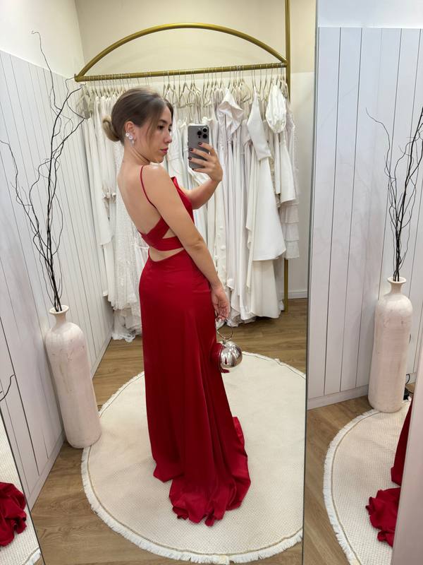 Vestido longo vermelho de alça fina, costas abertas com recortes e caimento fluido.