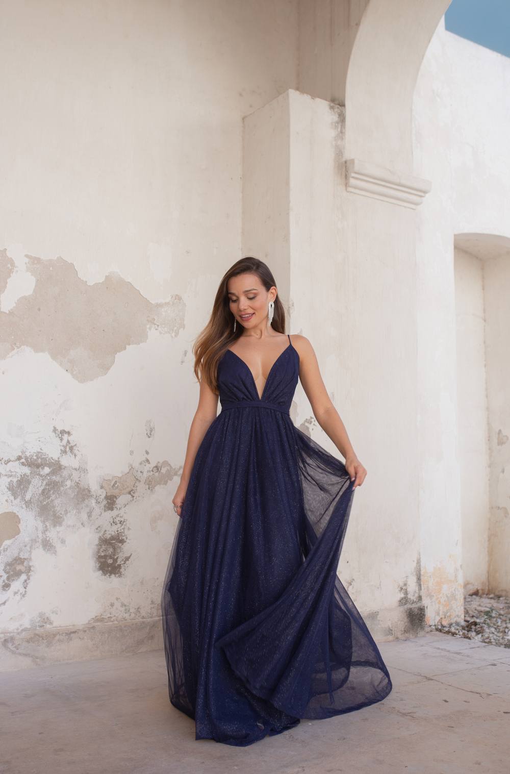 Vestido longo azul escuro com brilho, alças finas, decote em V e saia fluida.