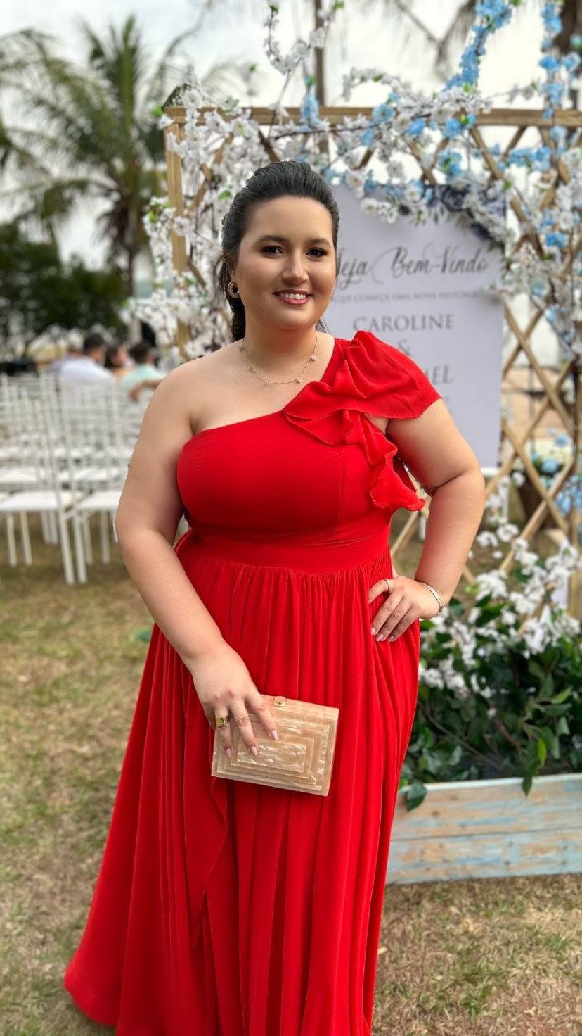 Vestido longo vermelho de um ombro só com detalhe de babado no decote e saia fluida.