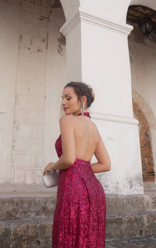 Vestido longo fúcsia com brilho de paetês, modelagem frente única e costas nuas.