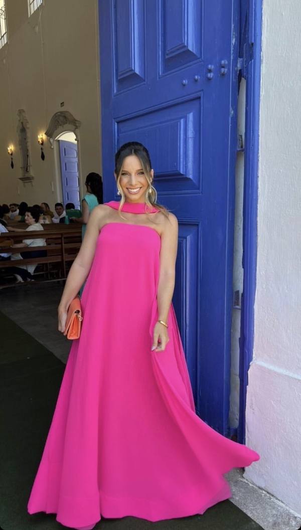 Vestido longo fúcsia fluido com decote tomara que caia e detalhe de faixa no pescoço.