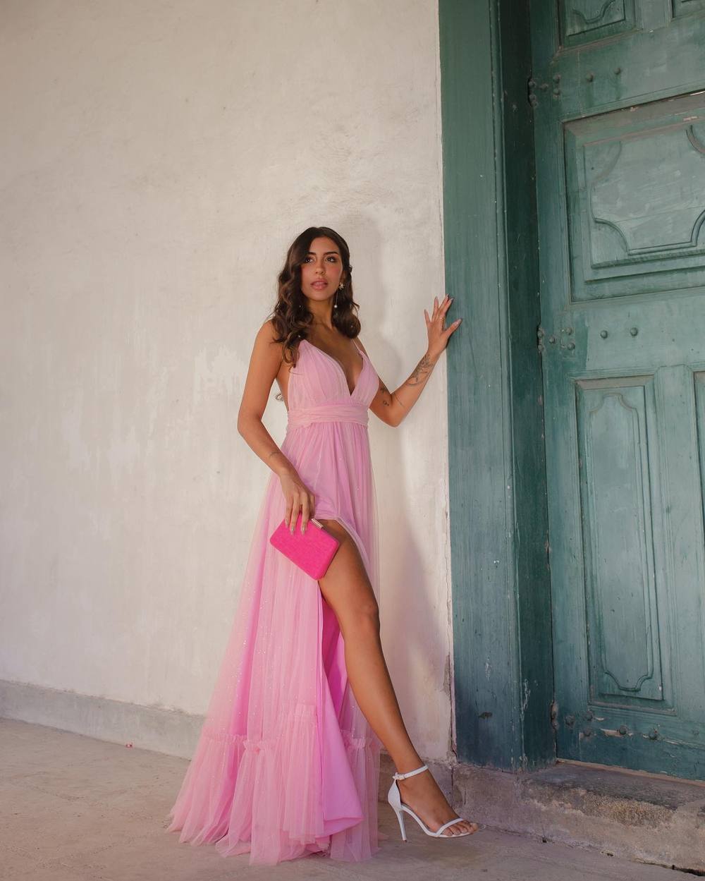 Vestido longo rosa de tule com alças finas, decote V profundo, saia fluida e fenda lateral.