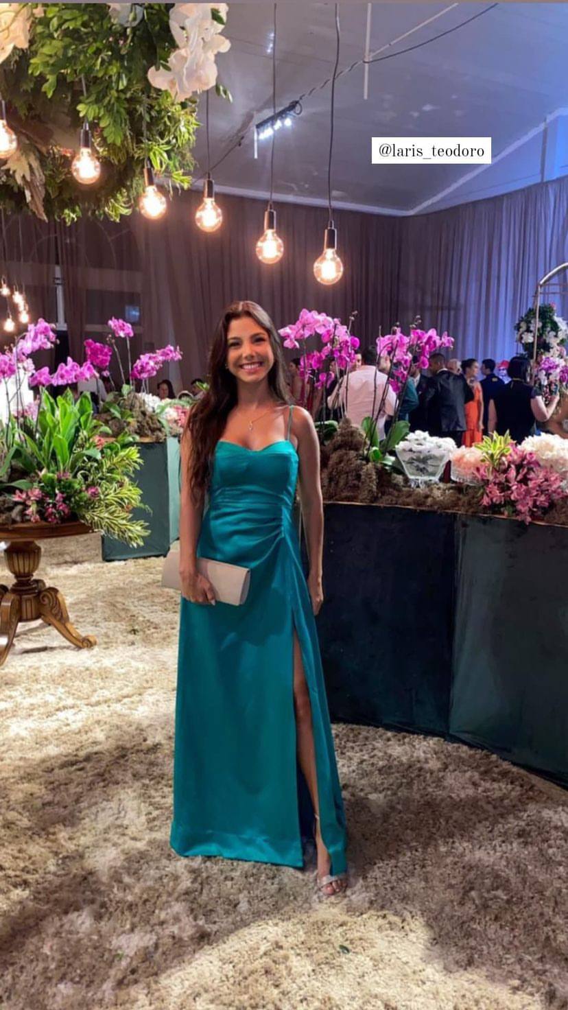 Vestido longo verde de cetim com alças finas, detalhe franzido na cintura e fenda lateral na saia.
