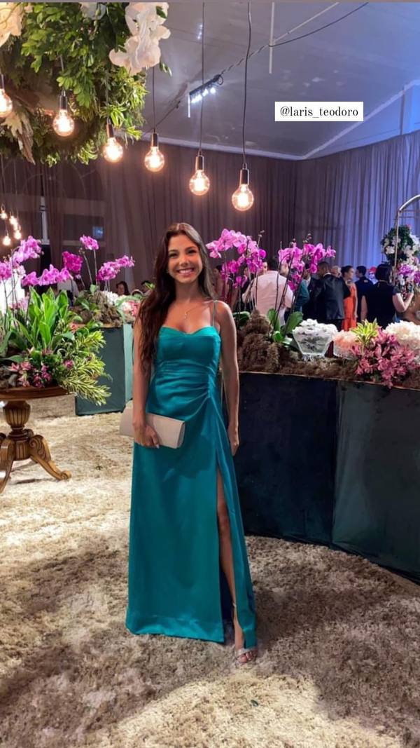 Vestido longo verde de cetim com alças finas, detalhe franzido na cintura e fenda lateral na saia.