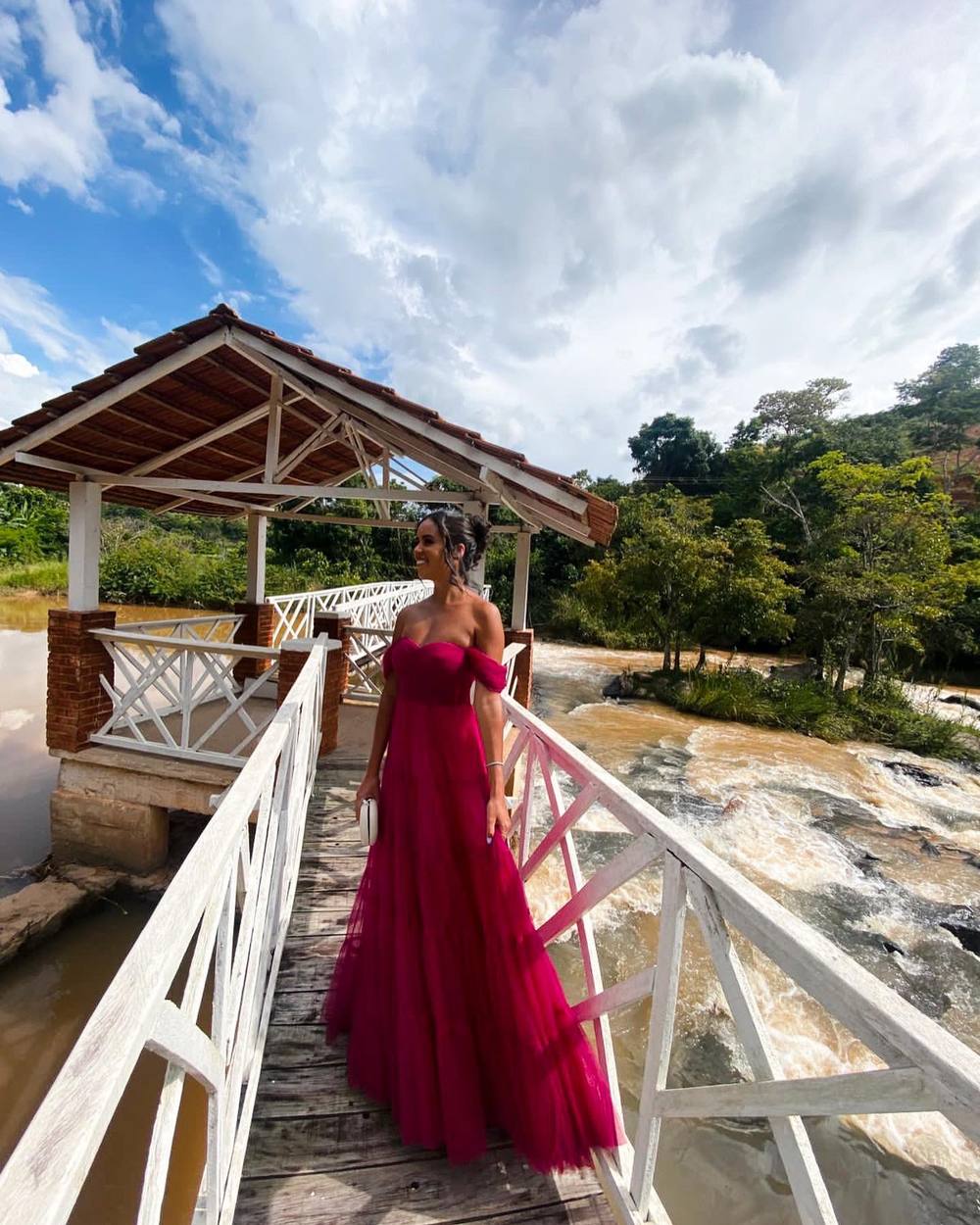 Vestido longo fúcsia de tule, decote tomara que caia com ombros caídos e saia fluida evasê.