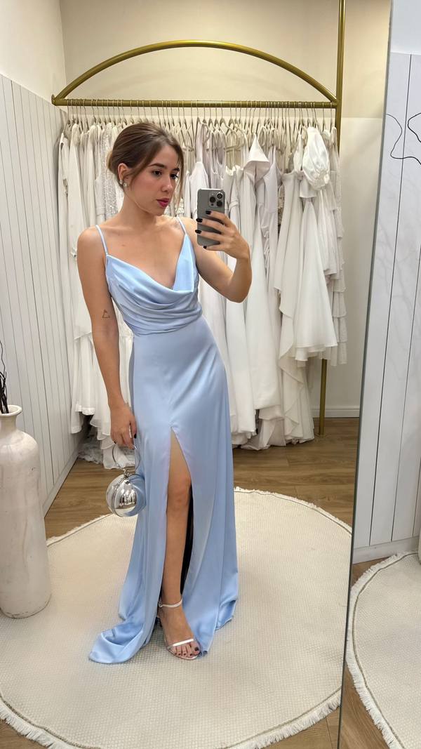 Vestido longo azul claro em cetim, de alça fina com decote degagê e fenda na saia.