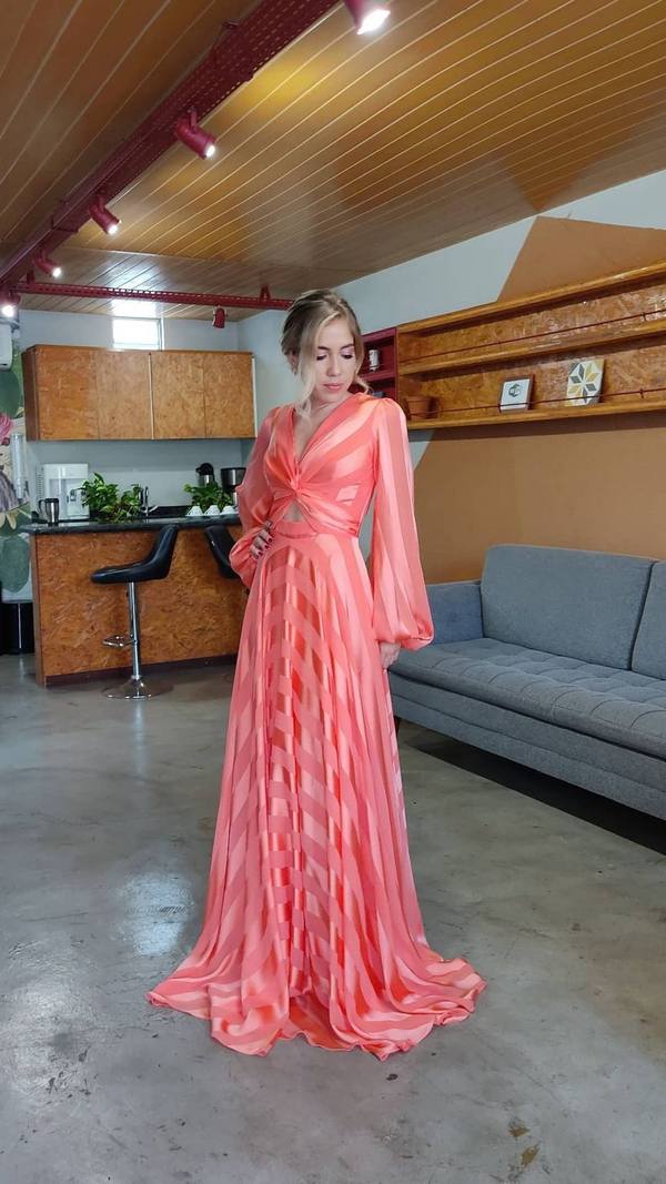 Vestido longo coral listrado, com mangas longas bufantes, decote V transpassado e saia fluida.