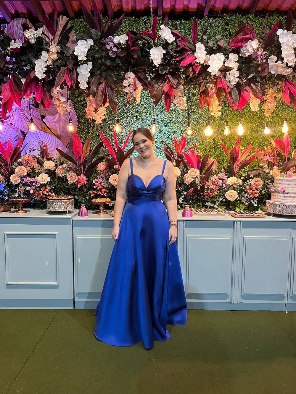 Vestido longo azul em tecido acetinado, com alças finas, decote corações drapeado e saia evasê fluida.