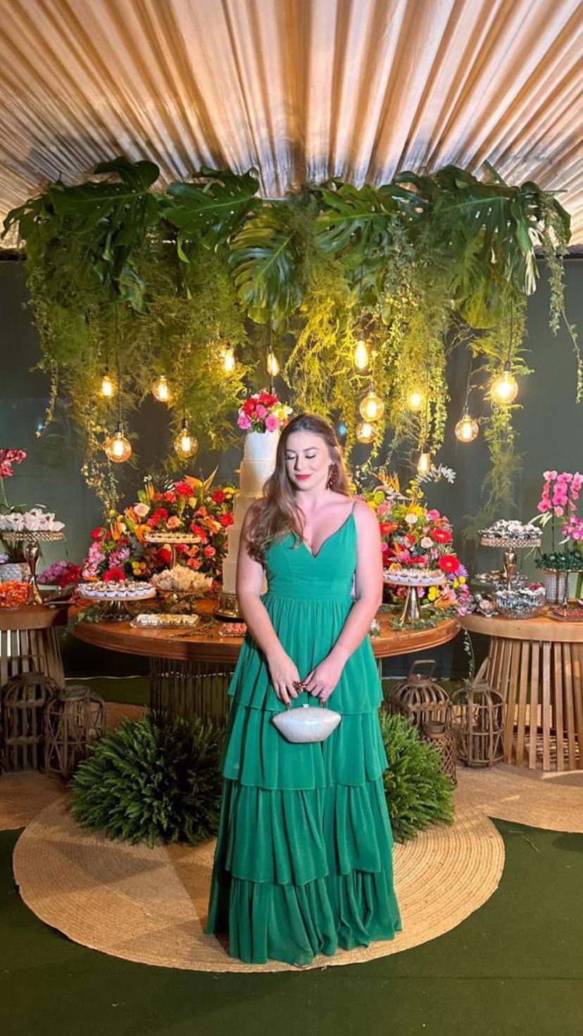 Vestido longo verde de alças finas, decote em V e saia fluida com babados em camadas.