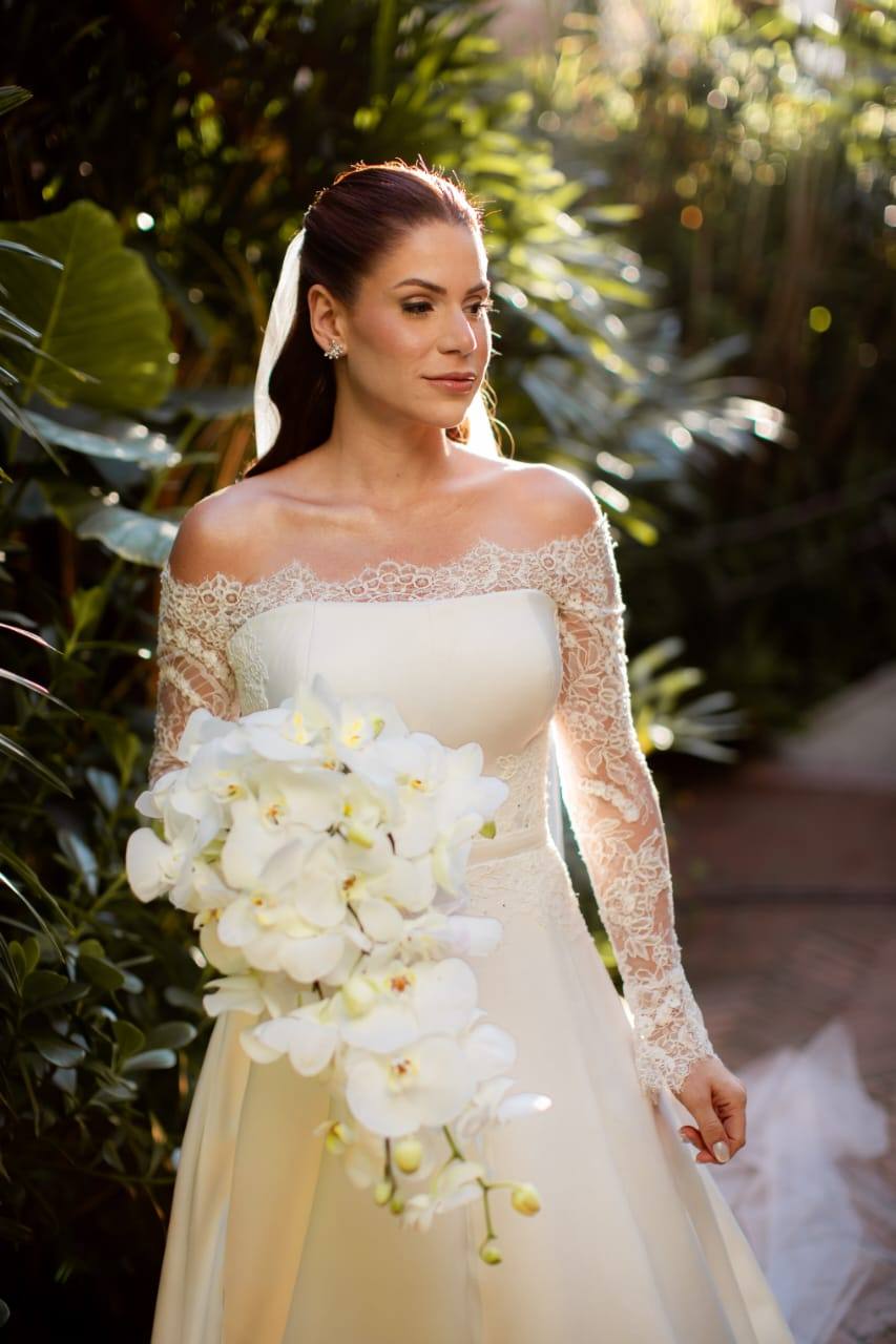 Vestido de noiva off-white de manga longa em renda, com buquê de orquídeas, foto 3